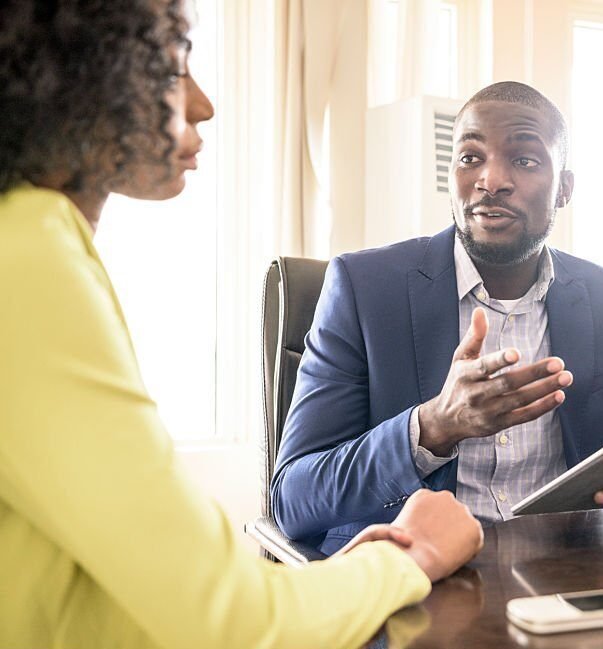 Three young Nigerian business people in modern office having meeting, Nigeria, Africa.